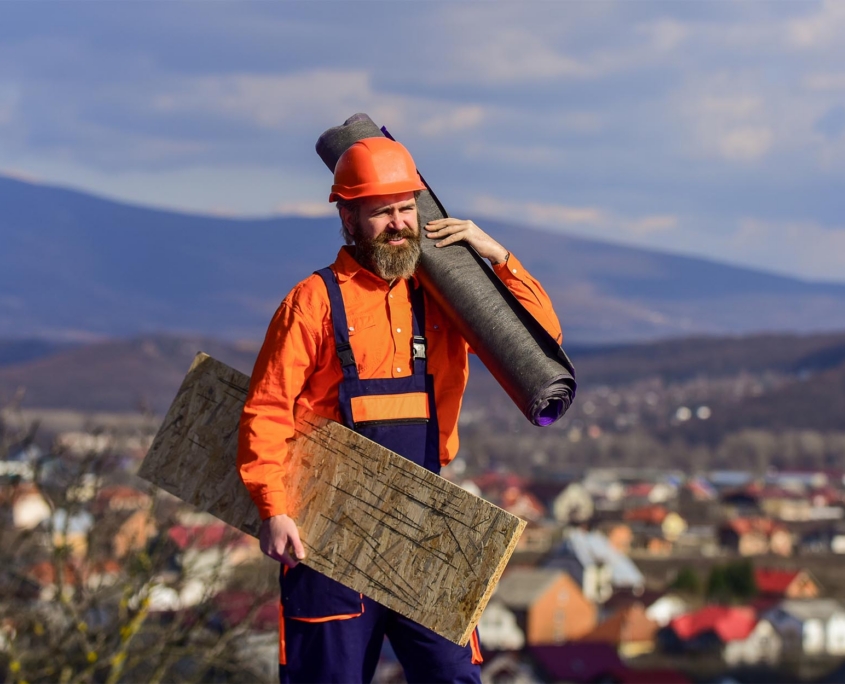 Side View Of A Man Holding Roofing Materials