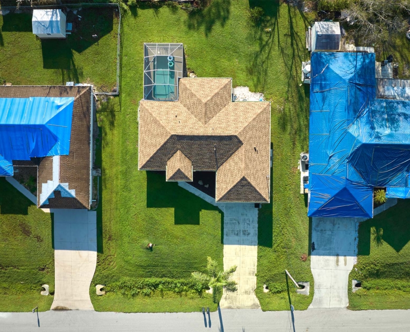 Damaged House Rooftop Covered With Protective Plastic Tarp